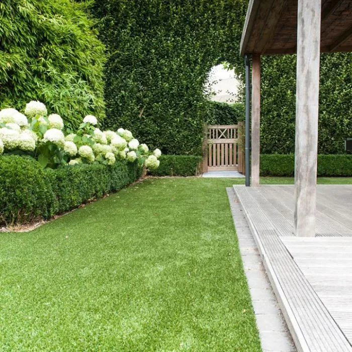 Artificial grass garden pathway flowing into planted borders