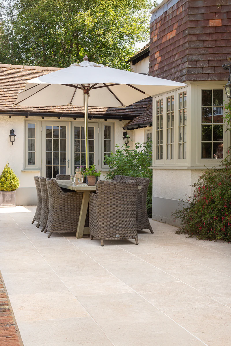 Natural stone patio dining area in a landscaped garden by SureLay UK
